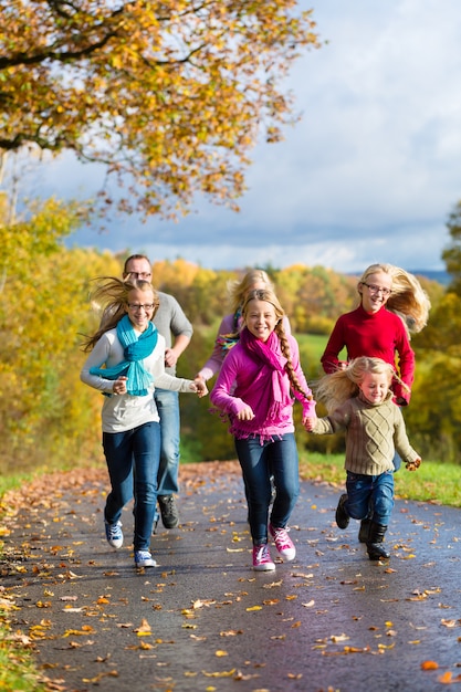 La famiglia fa una passeggiata nella foresta di autunno