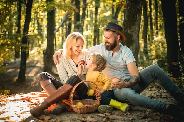 La famiglia felice al picnic nutre il figlio di 34 anni con mele senza pesticidi Sane abitudini alimentari Veget