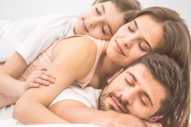 La famiglia felice che dorme sul letto