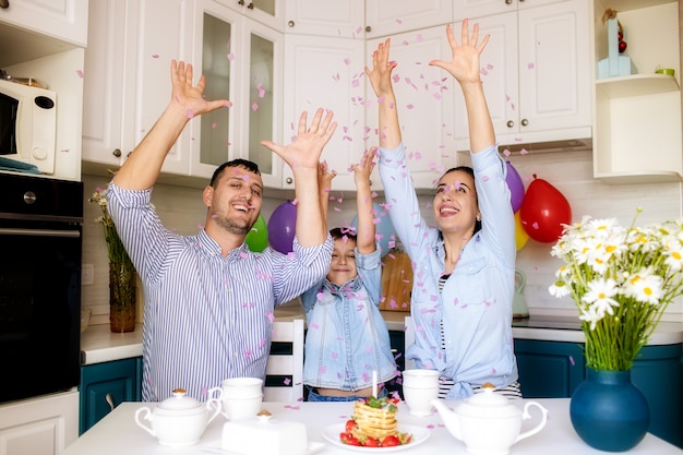 La famiglia felice festeggia il compleanno a casa in cucina