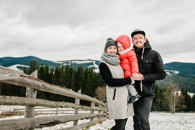 La famiglia felice si diverte e gioca in inverno nevoso, cammina nella natura della montagna. Figlia di padre, madre e figli che gode del viaggio. Frost stagione invernale.