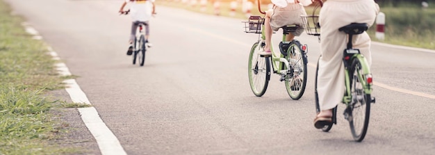 La famiglia felice sta andando in bicicletta all'aperto Sfondo banner