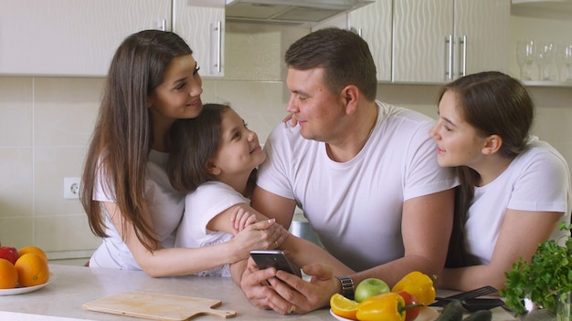 La famiglia felice utilizza uno smartphone per fare acquisti su Internet