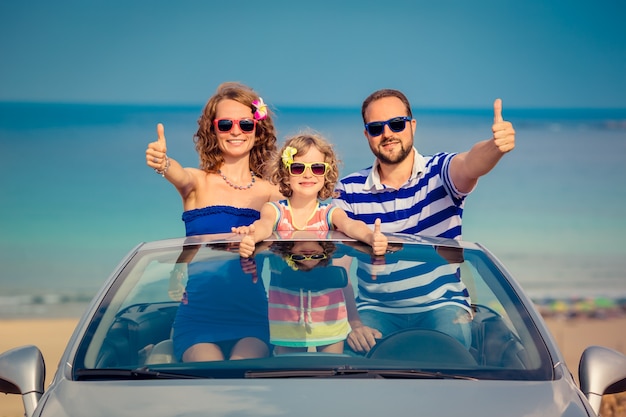 La famiglia felice viaggia in auto al mare Persone che si divertono in cabriolet Concetto di vacanza estiva