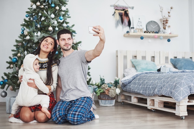 La famiglia si è raccolta intorno ad un albero di Natale facendo un selfie