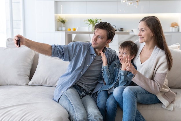 La famiglia si fa un selfie mentre è seduta sul divano di casa