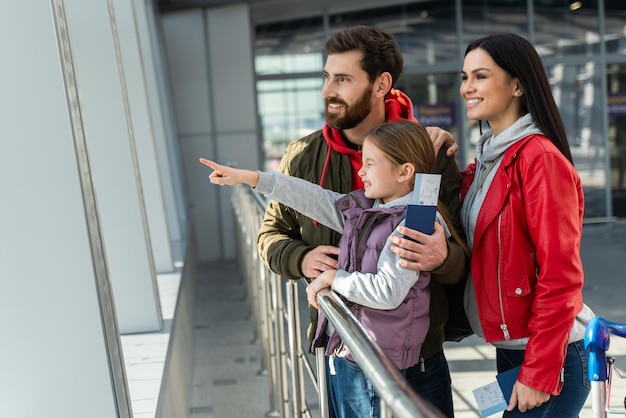 La famiglia si trova nella hall dell'aeroporto e in vita per l'aereo Concetti di viaggio