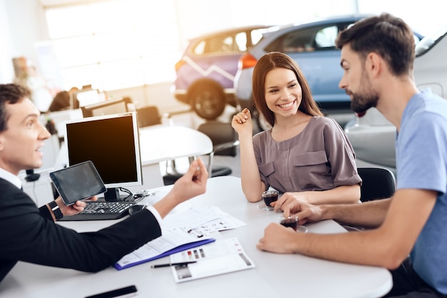 La famiglia sta scegliendo una nuova auto in Showroom.