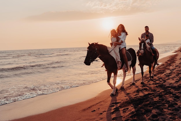 La famiglia trascorre del tempo con i propri figli mentre vanno a cavallo insieme su una spiaggia sabbiosa. Messa a fuoco selettiva. Foto di alta qualità