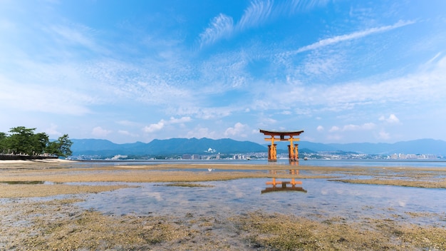 La famosa porta shintoista giapponese galleggiante arancione (Torii) del santuario di Itsukushima con riflessione , isola di Miyajima della prefettura di Hiroshima, Giappone