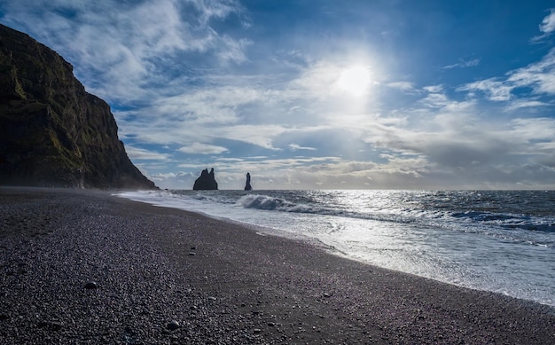 La famosa spiaggia dell'oceano di sabbia nera monte Reynisfjall e le pittoresche colonne di basalto Vik Sud Islanda persone irriconoscibili