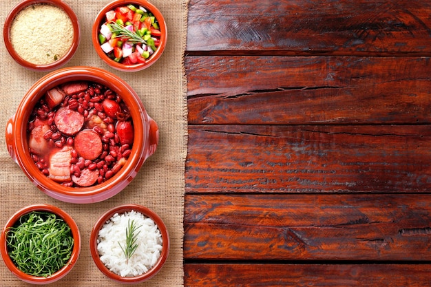 La feijoada brasiliana cibo tradizionale della cucina brasiliana su una casseruola in ceramica sopra un tavolo in legno rustico Copia spazio