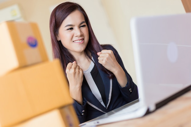 la felicità e la gioiosa donna asiatica fanno shopping online