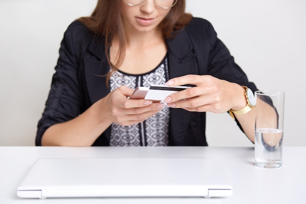 La femmina tiene lo Smart Phone e la carta di plastica