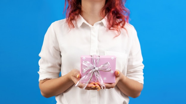 La femmina tiene una confezione regalo sul concetto di vacanza sfondo blu