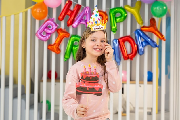 La festeggiata con un cappello festivo con pipa e oggetti di scena si sta divertendo