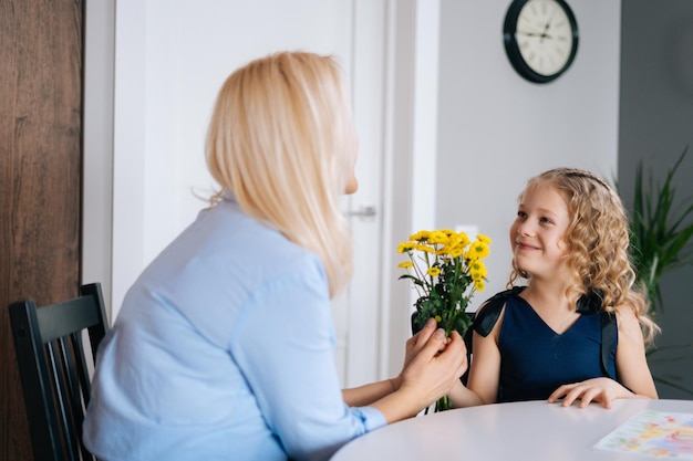 La figlia amorevole regala fiori bouquet a sua madre La ragazza fa un regalo alla sua amata madre Concetto di felice festa della mamma