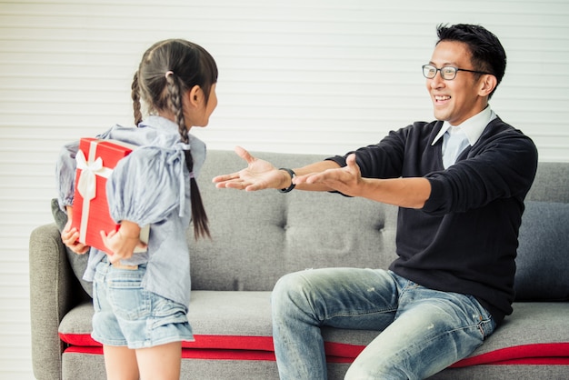 La figlia asiatica dà il presente per il padre. concetto di regalo a sorpresa per la festa del papà.