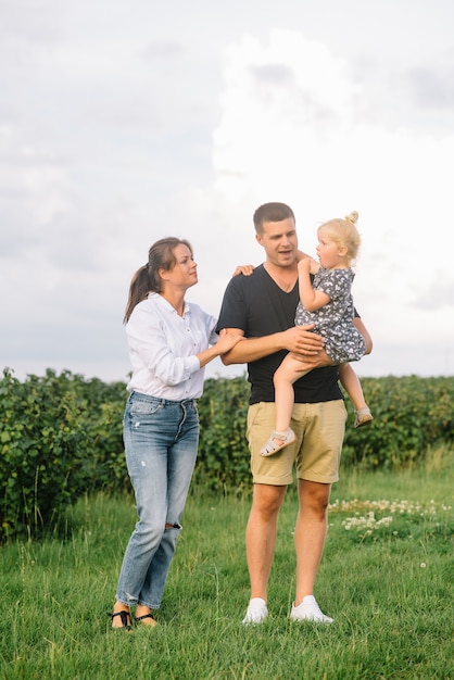 La figlia che abbraccia i genitori sulla natura.