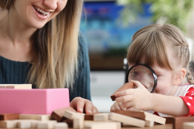 La figlia esamina tramite la lente la barra di legno