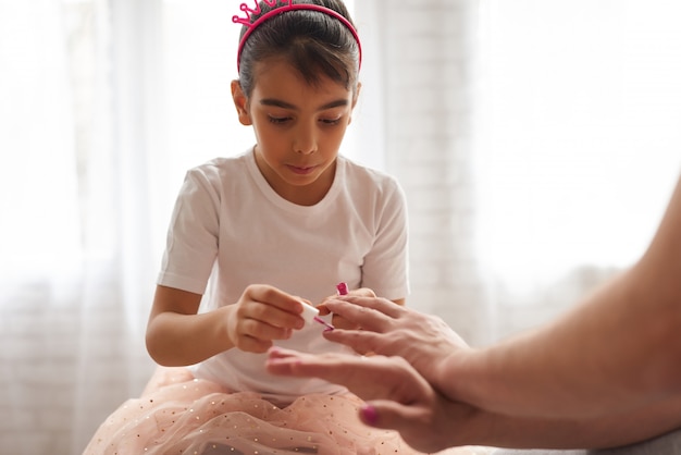 La figlia sta dipingendo le unghie dei papà con.