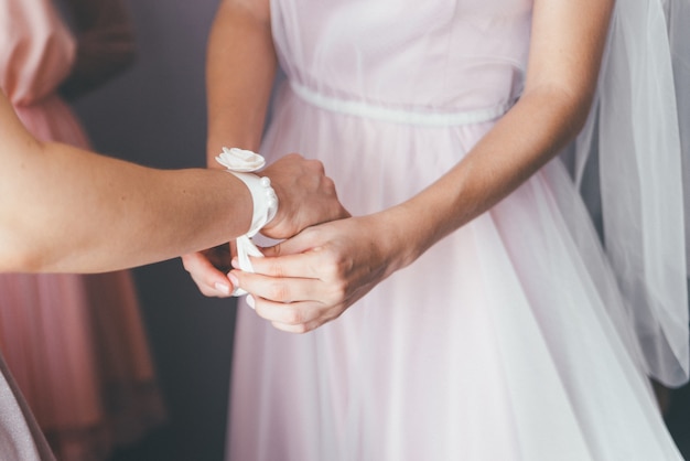 La fine della sposa mette sui suoi accessori di cerimonia delle domestiche