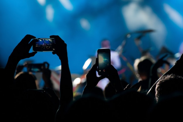 La folla del concerto prende video e foto del concerto sul telefono