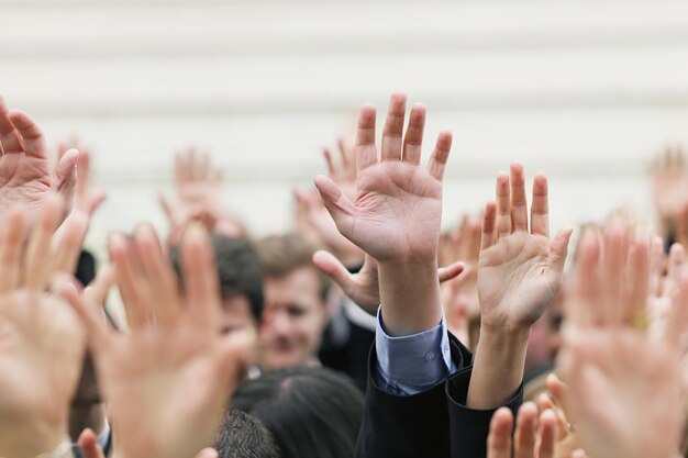 La folla di persone che alzano le mani si concentra sulle mani