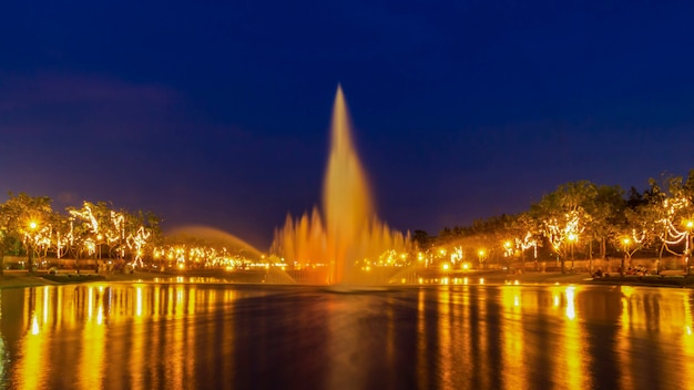 La fontana e la riflessione degli effetti della luce alla notte, parcheggiano a Bangkok, Tailandia.