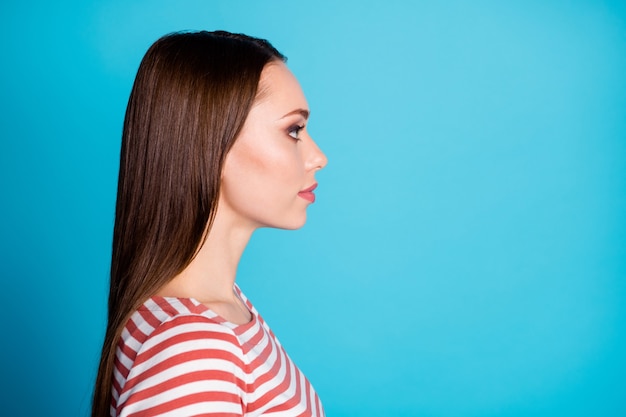 La foto a lato del profilo di una bella ragazza attraente guarda copyspace ascolta il suo dipendente indossare una maglietta in stile casual isolata su uno sfondo di colore blu