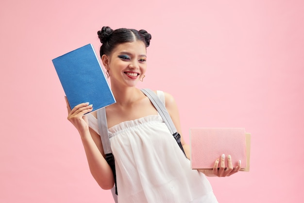 La foto a lato del profilo di una ragazza positiva tiene i libri di copia andare a piedi in aula lezione lezione biblioteca isolata su sfondo rosa