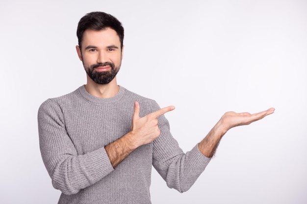 La foto del giovane indica la promozione del prodotto delle dita pubblicizza la vendita di decisione isolata su uno sfondo di colore grigio