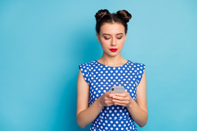 La foto del telefono grazioso della tenuta della signora guarda seriamente lo schermo