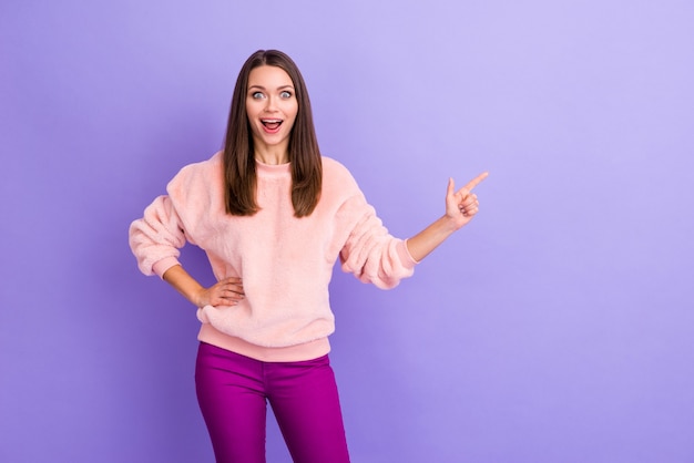 La foto della signora che indica il fronte eccitato dello spazio vuoto del dito sulla parete viola