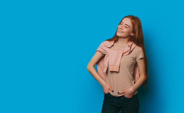 La foto di un'affascinante ragazza di mezza età con un sorriso gioioso in posa in una bella maglietta coperta da un maglione