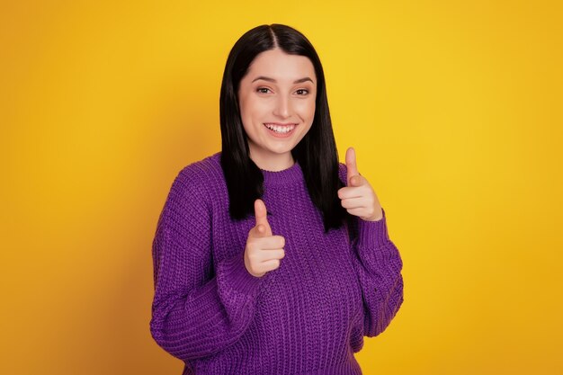 La foto di una giovane donna attraente isolata sul muro giallo ti punta il dito contro con un'espressione sicura