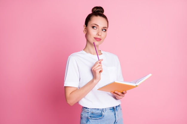 La foto di una ragazza intelligente e curiosa scrive una matita da quaderno che pensa che i pensieri decidano la decisione del progetto