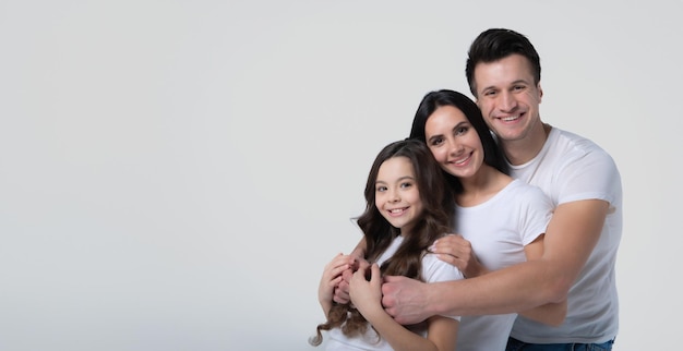 La foto ravvicinata di un gruppo di famiglia bello e sorridente sta posando con una maglietta bianca mentre sono isolati su sfondo bianco in studio