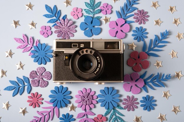 La fotocamera retrò è decorata con fiori e foglie