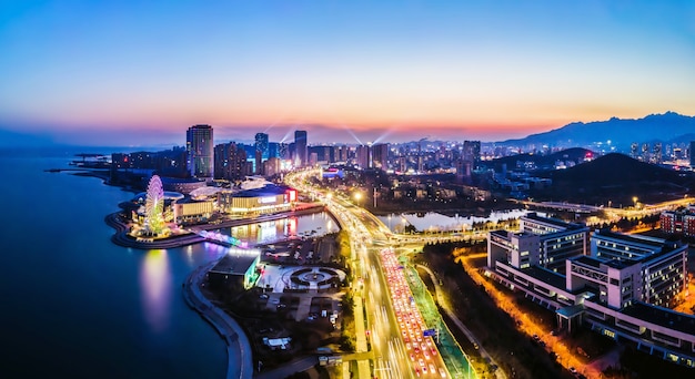 La fotografia aerea della vista notturna del paesaggio architettonico urbano di Qingdao, Cina