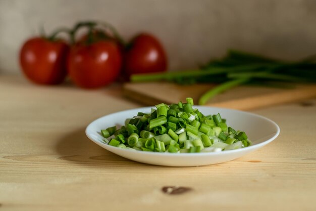 La fotografia scura del tagliere con ramo di pomodori e cipollotto