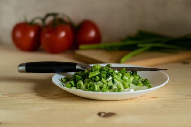 La fotografia scura del tagliere con ramo di pomodori e cipollotto