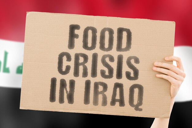 La frase Crisi alimentare in Iraq è su uno striscione nelle mani degli uomini con una bandiera irachena sfocata sullo sfondo Crisi Finanza Vita Nutrizione Pane Disastro Crollo Problema sociale