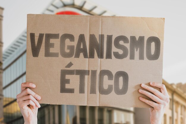 La frase Veganismo etico su uno striscione nelle mani degli uomini Nutrizione sana Niente carne Credenza filosofica Cruelty free Cibo vegetale Protezione degli animali Animali