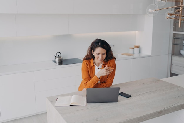 La freelance femminile in cuffia comunica tramite videochiamata sul laptop lavorando da casa Lavoro a distanza