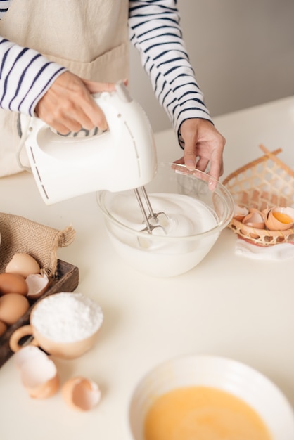 La frusta da cucina con panna montata e crema pasticcera ruota rapidamente