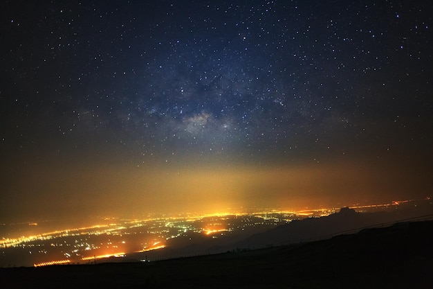 La galassia della Via Lattea e la luce della città a Phutabberk Phetchabun in Thailandia Fotografia a lunga esposizione