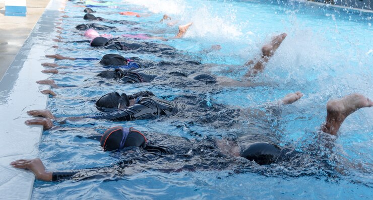 La gamba ha sparato del bambino alla classe della piscina che impara nuotare