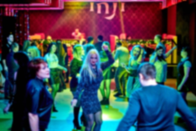 La gente balla sulla pista da ballo in discoteca, molte persone. Luci stroboscopiche luminose
