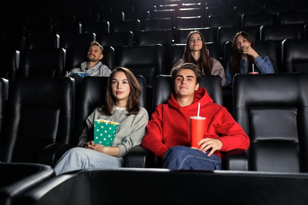 La gente beve limonata e mangia popcorn alla prima di un film al cinema